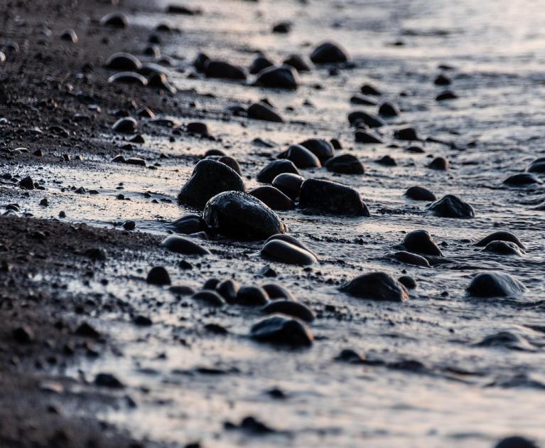 Wet pebbles on the shore, twilight reflections.