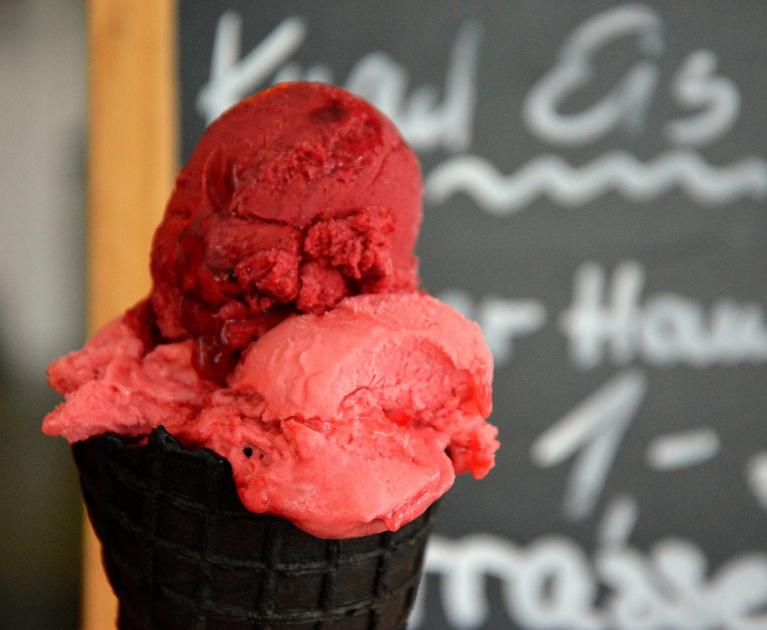 Vibrant red ice cream on a black cone, an irresistible summer delight.