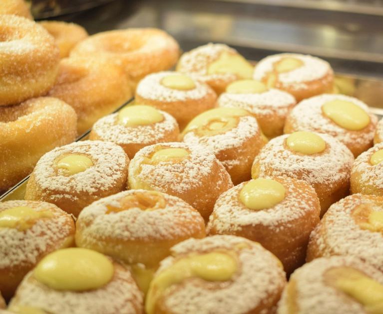 Delicious soft donuts with cream and powdered sugar, an irresistible invitation.