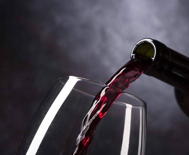 Red wine pouring into glass, elegance and sensory delight.