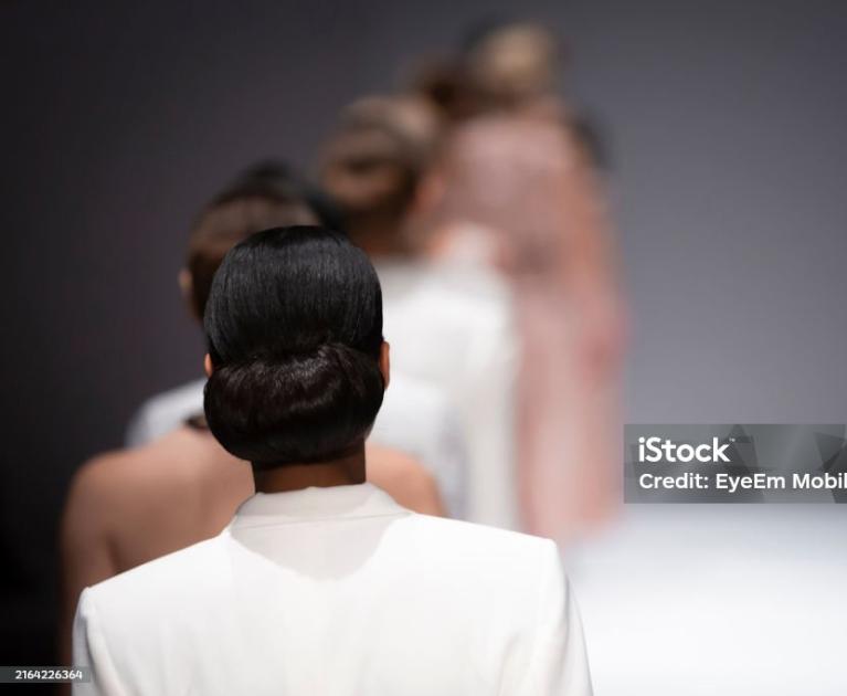 Elegant runway, models in line, sophisticated and minimalist atmosphere.