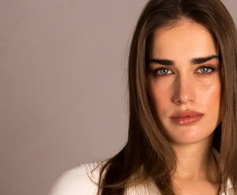 Woman with long brown hair, an intense and serene gaze.