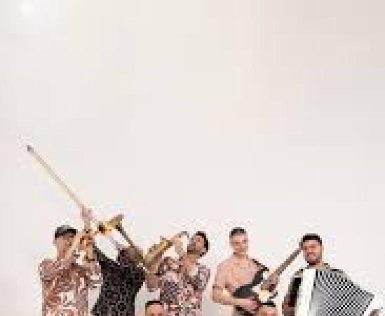 Lively band with instruments, colorful attire, and joyful atmosphere.