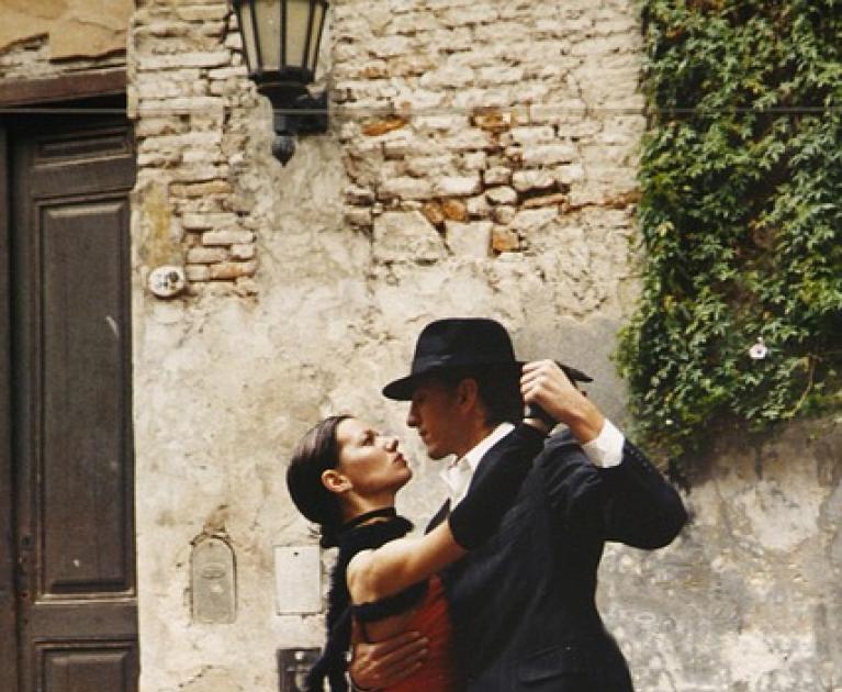 Passionate couple dances tango on street, romantic and intense atmosphere.