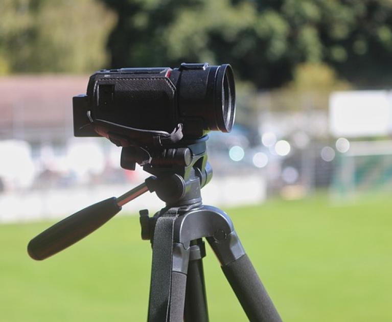 Camcorder on tripod, ready to capture special moments on the green field.