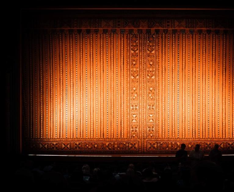 Golden curtain, theatrical atmosphere, vibrant anticipation, silent audience.
